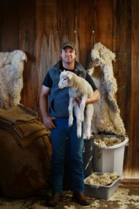 Casey Mazzucchi at his Valley Ford Mercantile and Wool Mill in Valley Ford, California with Rose, his 3-month-old pet Horned Dorset sheep. (Erik Castro / For The Press Democrat)