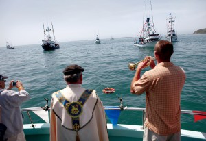 Trumpet player Nicholas Stephens plays 'Taps' after Father Robert White placed a memorial wreath on the water Sunday to remember lost fishermen during the blessing of the fleet in Bodega Bay. (BETH SCHLANKER/ The Press Democrat, file 2012)