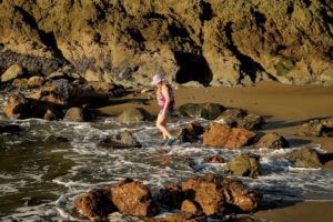 Cleo Cat of Occidental looks through the tide pools for small gem stones at Portuguese Beach. (photo by Conner Jay)