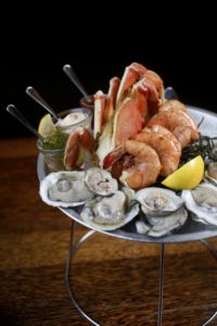 The medium seafood platter with peel and eat Gulf prawns, Blue Point oysters, littleneck clams, and half a Dungeness crab with a variety of dipping sauces at Willi's Seafood and Raw Bar in Healdsburg. (photo by Beth Schlanker)