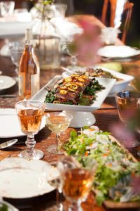 Firefly Catering often serves meals family-style, such as this salad served in a bountiful bowl and duck and kale dish.