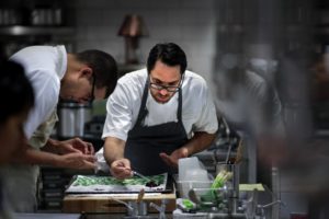Christopher Kostow chef ofThe Restaurant at Meadowood, working in the kitchen sorting vegetable leaves.