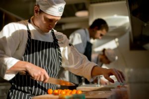 Zachary Stoller prepares tomatoes to be used in a tomato-cucumber green salad with gooseberry vinagrette at the Culinary Institue of America's The Conservatory at Greystone, in St. Helena. (photo by Alvin Jornada)