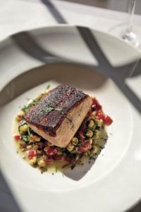 Chef Andrew Truong’s blackened salmon is served atop a medley of roasted summer vegetables and farro at Terrapin Creek in Bodega Bay.