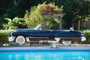 A working Cadillac nicknamed Colby Red serves as a backdrop.