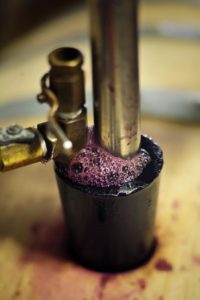 Wine bubbles up as barrels are filled at Punchdown Cellars in Santa Rosa on Thursday, July  17, 2014. (Conner Jay/The Press Democrat)