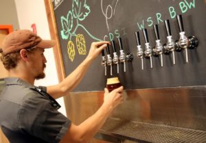 Seth Wood pouring beer at Woodfour Brewing Company in The Barlow in Sebastopol. (photo by Crista Jeremiason)