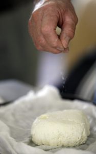 Panir is salted before being formed into a brick during the Farm to Table cheese making seminar during the Annual Artisan Cheese Festival. (photo by Crista Jeremiason)