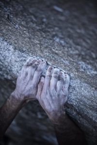 Free climbing El Capitan's Dawn Wall. Kevin Jorgeson curls his fingers on top of a granite edge. (photo by Corey Rich)