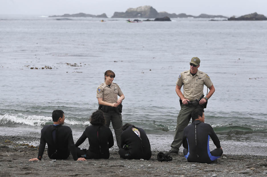 Wardens Kathleen Boele and Todd Kinnard detain divers who were cited for multiple abalone hunting violations at van Damme State Park.