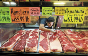 Butcher Freddy Castañeda fills the meat counter at Castañeda's Marketplace in Windsor with traditional Mexican cuts of beef.