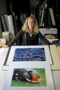 Lisa Kristine, shown with two of her photographs. (photo by Chris Hardy)