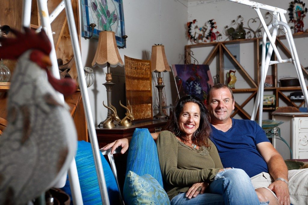 Leslie Boutell and Simon Purshouse, owners of Urban Refind, sit on a porch swing amongst many of their other wares at their shop in Sonoma, California on Thursday, October 15, 2015. (Alvin Jornada / The Press Democrat)