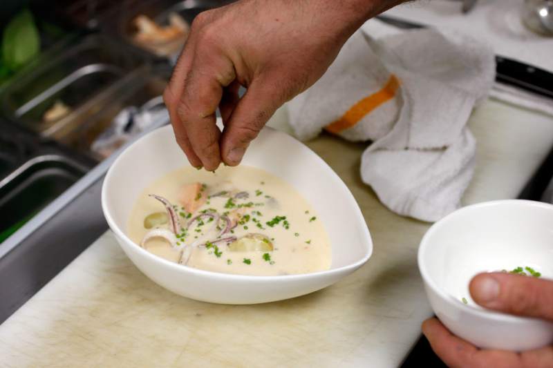 Sous chef Ari Chalfsky sprinkles chives onto the Seaside Showder he is preparing at Seaside Metal oyster bar in Guerneville, California on Wednesday, January 13, 2016. (Alvin Jornada / The Press Democrat)