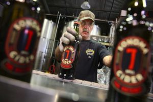 Mike West grabs bottles off the production line to pack into boxes at Sonoma Cider in Healdsburg, on Tuesday, March 1, 2016.   (Christopher Chung/ The Press Democrat)