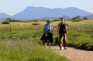 Debra Capri, left, and Chris Sittig take a morning hike along the Laguna de Santa Rosa trial with Mt. St. Helena in the background.   (John Burgess/The Press Democrat)