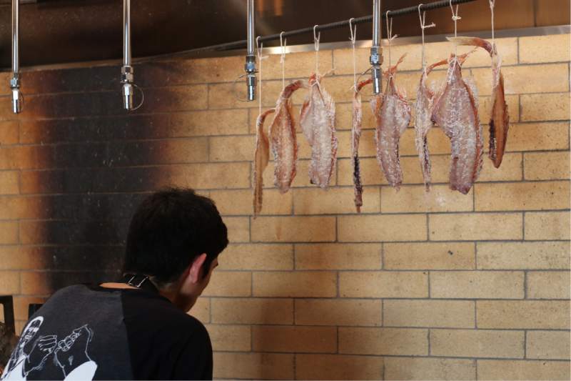 Smoked fish hanging above the grill at Miminashi restaurant in Napa. (Heather Irwin / The Press Democrat)