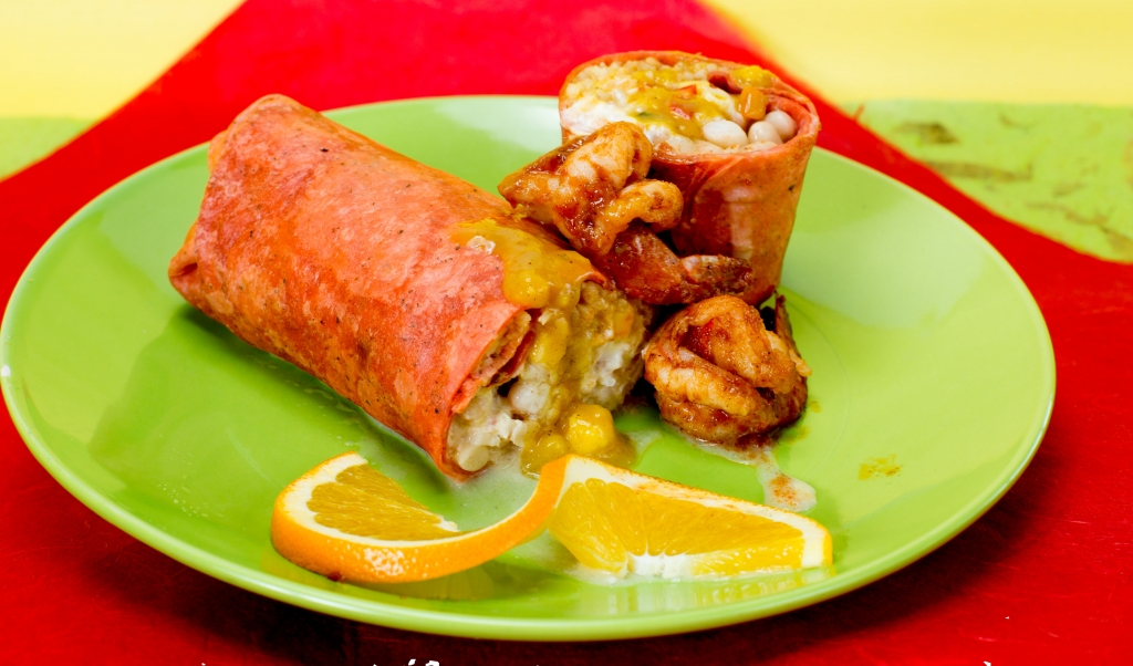 Sautéed prawns in bell peppers, mushrooms and onions, served with homemade Spanish rice, whole white beans, sour cream and fresh tropical mango salsa all wrapped in a tomato tortilla. 