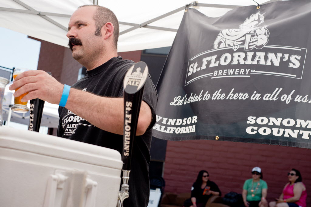 Aron Levin of St. Florian's Brewery pours beer for attendees of Sonoma County Beerfest in Santa Rosa. (Alvin Jornada / The Press Democrat)