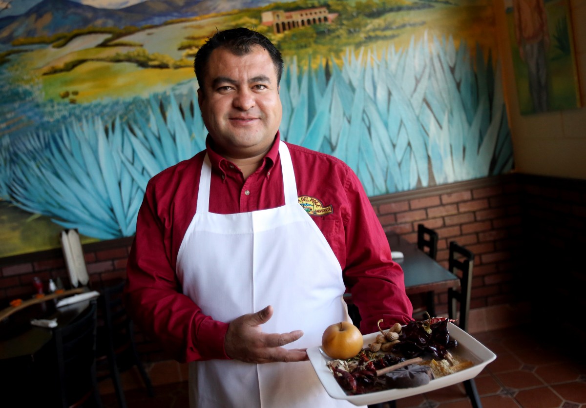 Octavio Diaz holding ingredients he uses to make a mole sauce at his restaurant Agave Mexican Restaurant and Tequila Bar in Healdsburg. (Crista Jeremiason / The Press Democrat) 