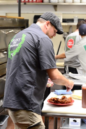 Chef Matt Hoffman prepares the chicken wings for service. The chicken wings with the savage sauce are a huge hit and a local favorite. (Photo by Tim Vallery) 