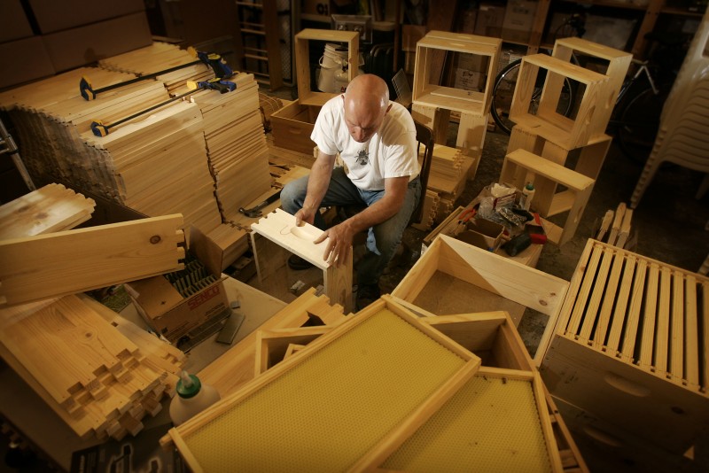 Doug Vincent, owner of Beekind, builds bee boxes in his Sebastopol store for the apples and asian pears at Gabriel Farms. Each box will be stocked with 10,000 bees contained in the screened box. photo by John Burgess