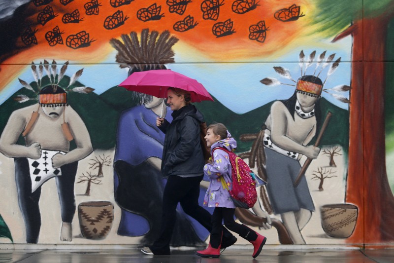 A student and parent walk past a mural that was painted over a wall that had been spray painted with anti-immigrant messages and Donald Trump's name. Photo taken before the start of school at Cali Calmecac Language Academy in Windsor, on Friday, January 20, 2017. (BETH SCHLANKER