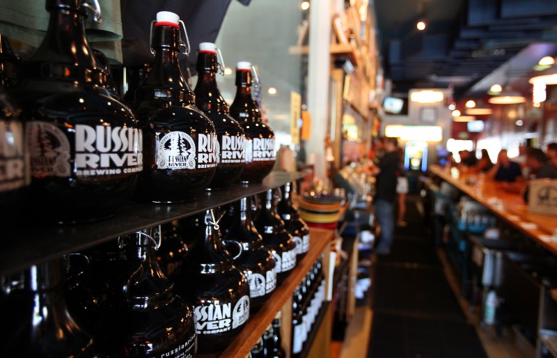 Growlers sit on a shelf behind the bar at Russian River Brewing Company, in Santa Rosa, on Wednesday, September 4, 2013. (Christopher Chung/ The Press Democrat) 