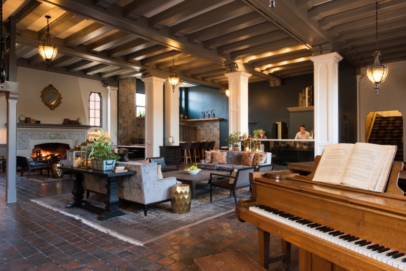 The hotel’s spacious lobby has its original tile flooring and imposing fireplace, with an antique baby grand piano guests are welcome to play.