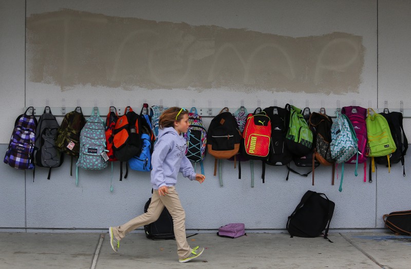 Fourth-grader Violet Meyer runs past the putlines of graffiti that had been covered over last October on the Cali Calmécac Language Academy Campus in Windsor. (Christopher Chung)