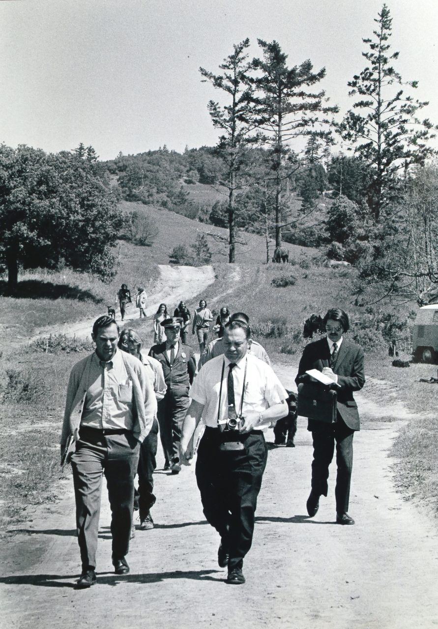 Inspectors and two uniformed Brinks guards walk onto Wheeler Ranch with attorney Corbin Houchins, at right, and deputies, May 1969. (Bob Fitch Archive, courtesy of the Department of Special Collections, Stanford University Libraries) 
