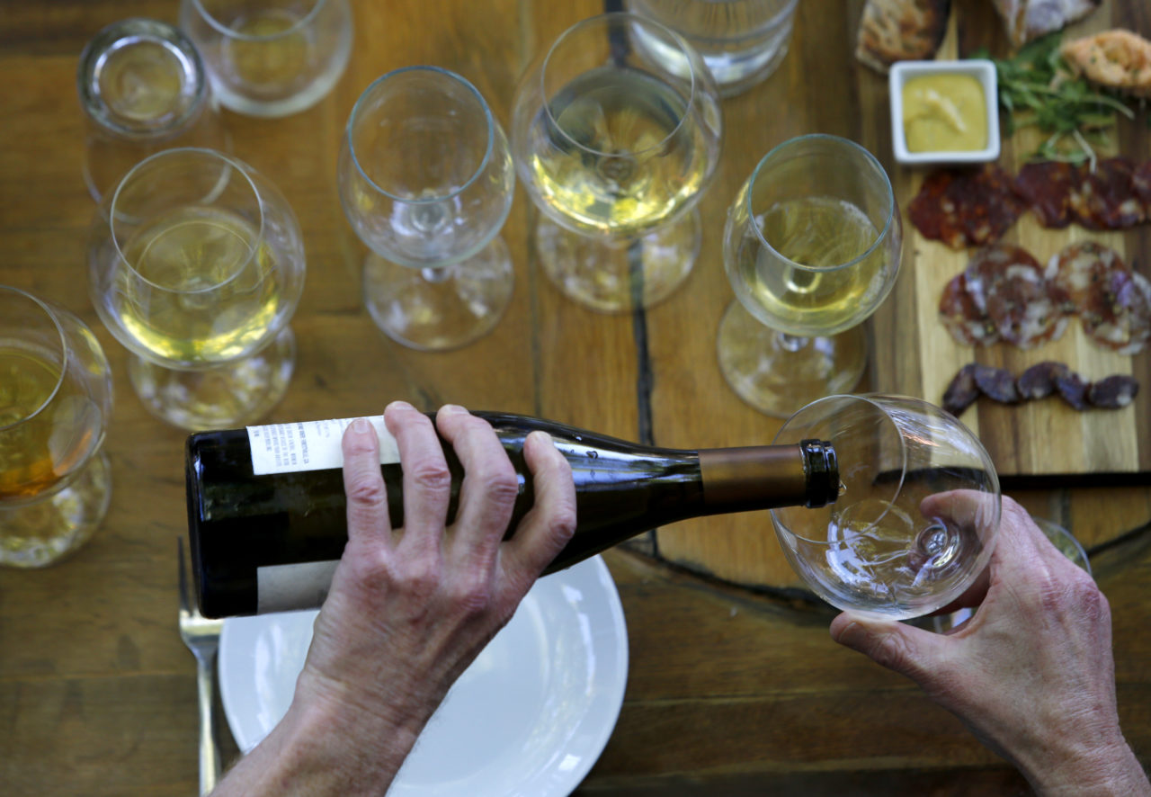 Dan Goldfield, a partner and winemaker at Dutton-Goldfield Winery, pours a glass of wine during a lunch for former colleagues from Hartford Court at Backyard in Forestville, on Monday, July 11, 2016. (BETH SCHLANKER/ The Press Democrat)