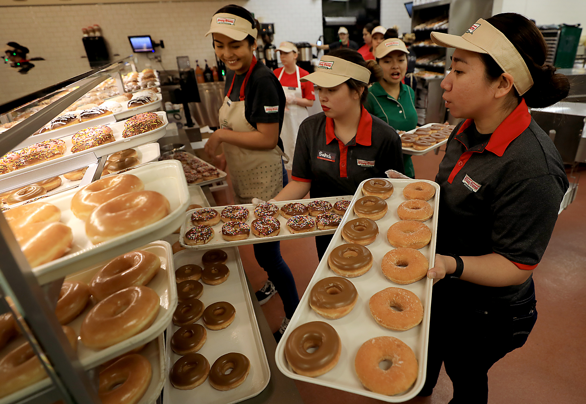 Employees stock the display case prior to the grand opening of the Krispy Kreme in Rohnert Park, Tuesday, Nov. 6, 2018. (Kent Porter / The Press Democrat)