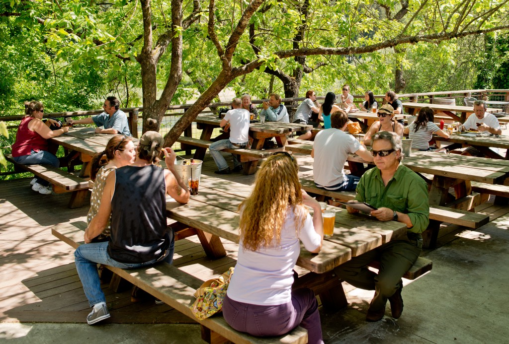 Guests enjoy cold drinks on the patio overlooking the Russian River at Stumptown Brewery in Guerneville.