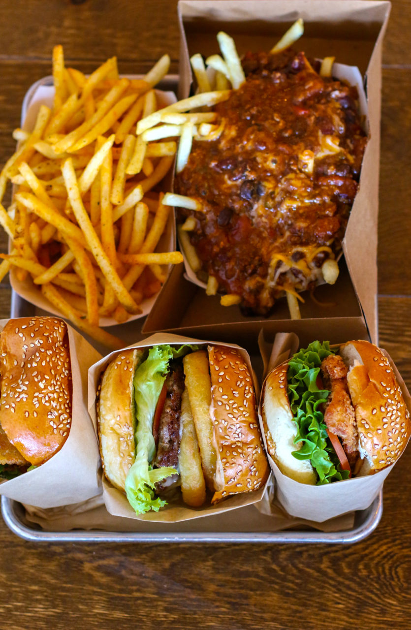 Sonoma Beef Burger with onion rings, fried chicken burger, chili fries and Cajun fries at Acme Burger in Cotati. (Heather Irwin/PD)