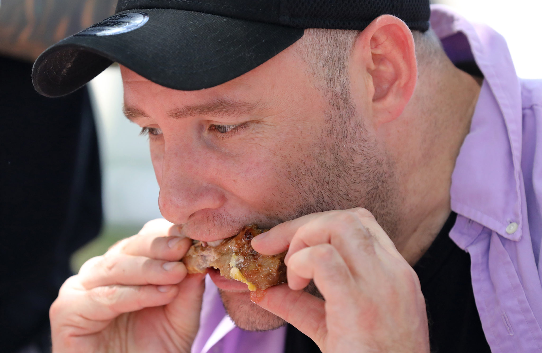 Stefan Rubin eats up a chicken wing on the opening day of the Sonoma County Fair in Santa Rosa on Thursday, August 1, 2019. (BETH SCHLANKER/ The Press Democrat)