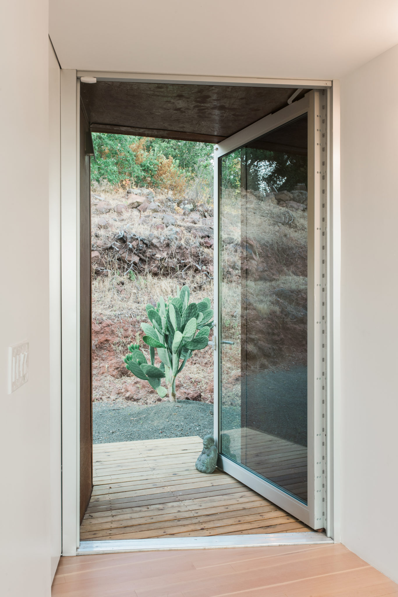 The modern home boasts many beautiful shapes such as this doorway that tapers to the outside. The cactus were planted not only for their visual appeal against the red rock, but also as a deterrent from guests wondering back to the master suite (Hollie says jokingly).