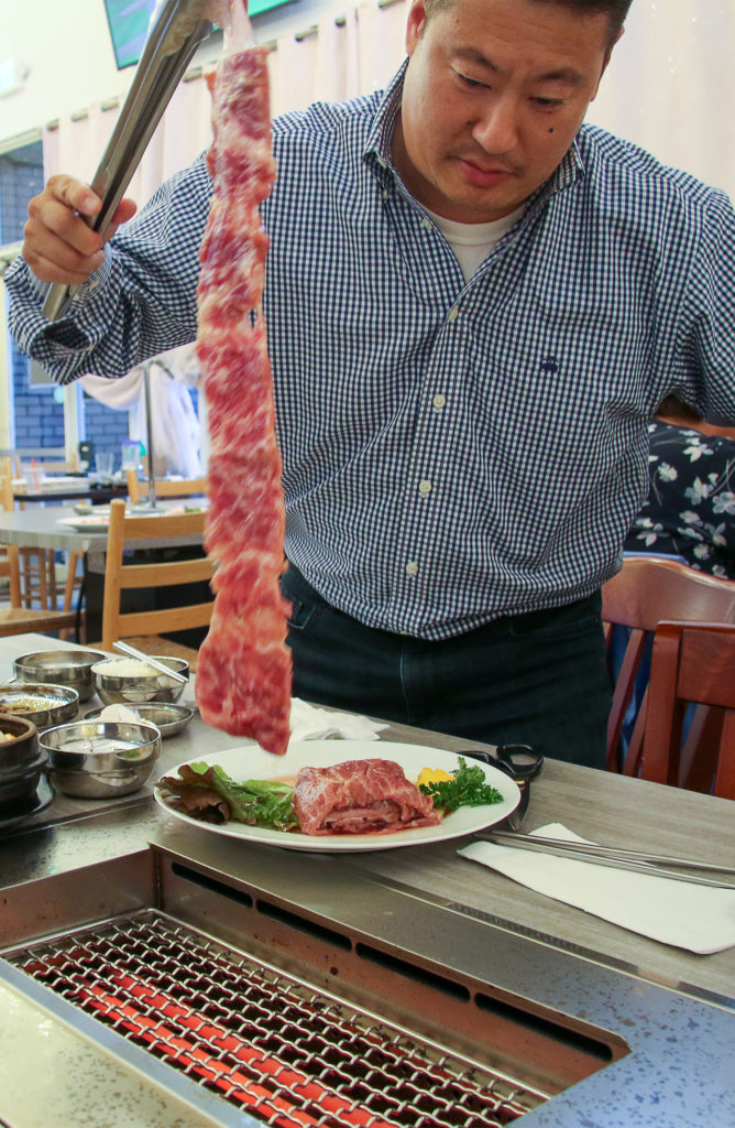 Han Soh demonstrating bbq cooking at Han Bul Korean BBQ in Santa Rosa. Heather Irwin/PD