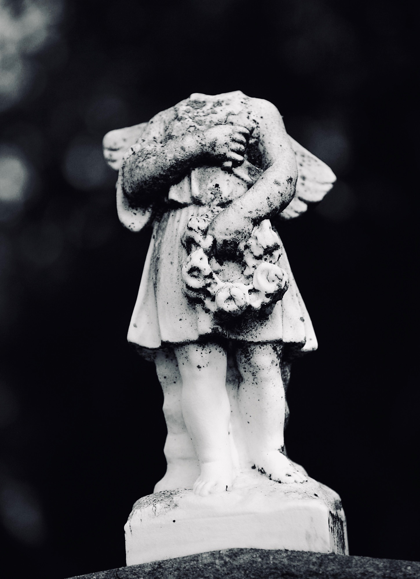 A statue with a missing head tops the grave of the Ramacciotti family in the Mountain Cemetery in Sonoma.