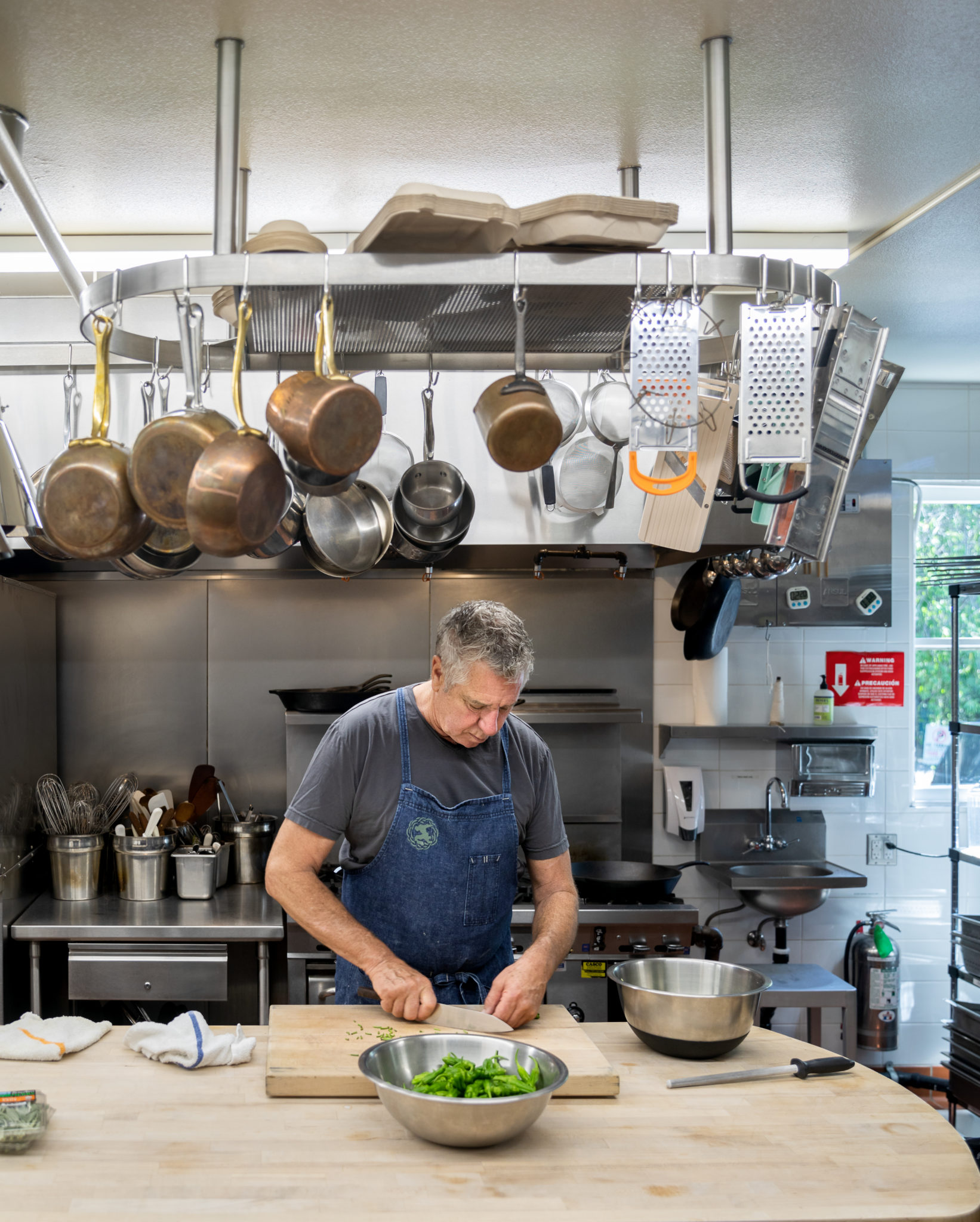 John McReynolds, culinary director of Stone Edge Farm in Sonoma Trimming padron peppers for Charred Padron Peppers with Goat Cheese and Sage