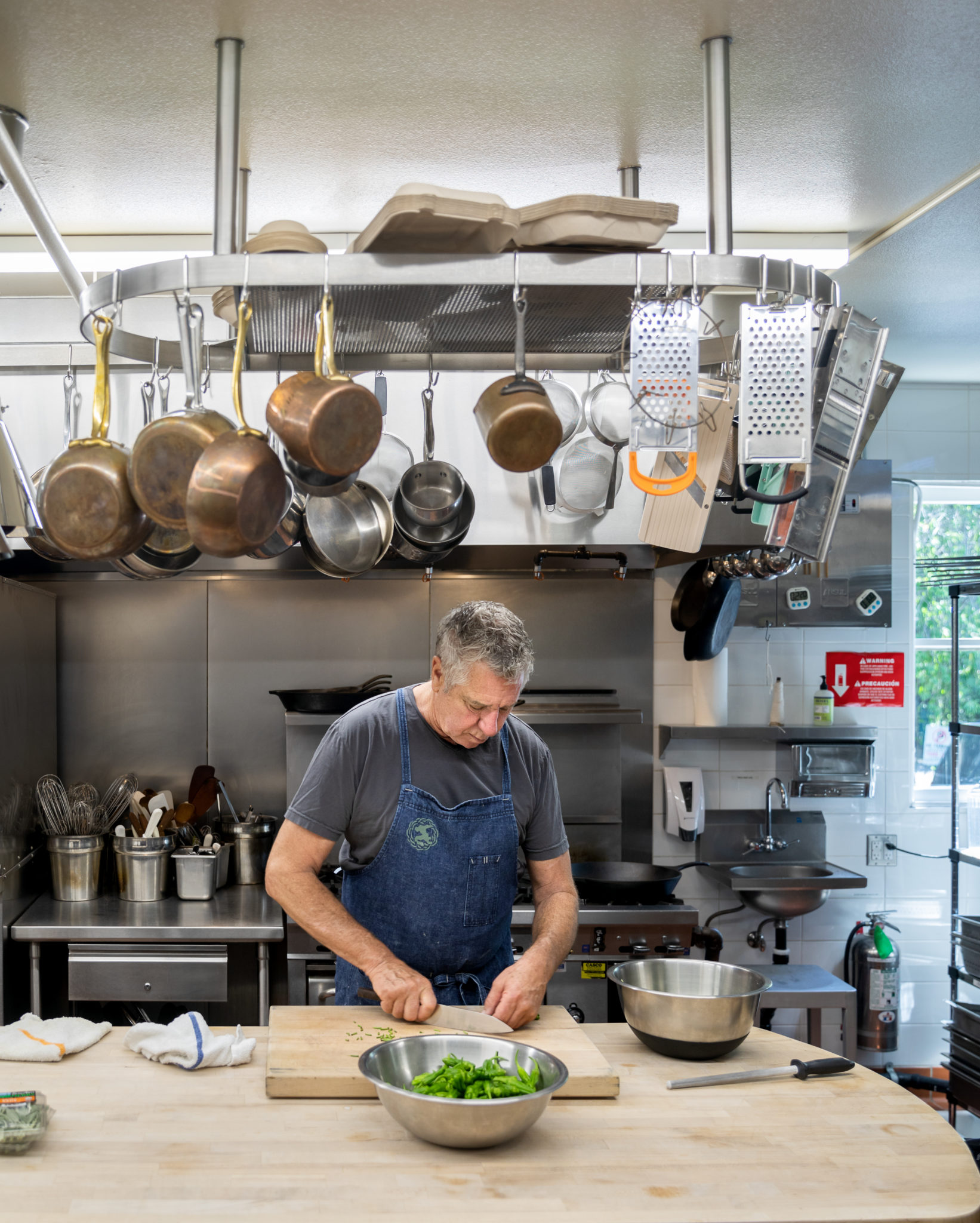 John McReynolds, culinary director of Stone Edge Farm in Sonoma Trimming padron peppers for Charred Padron Peppers with Goat Cheese and Sage