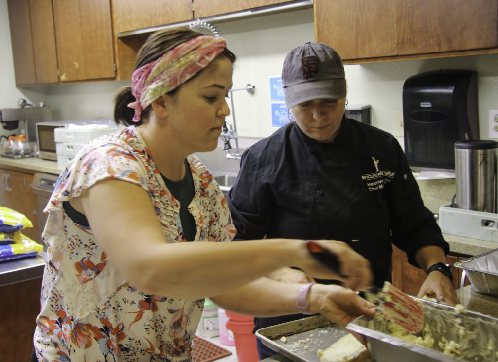 Chefs Katie Falese of KJ Wine Estates and Heather Ames of Sonoma Family Meal prepare garlic bread at the Healdsburg Senior Center on Thursday evening. Heather Irwin/PD
