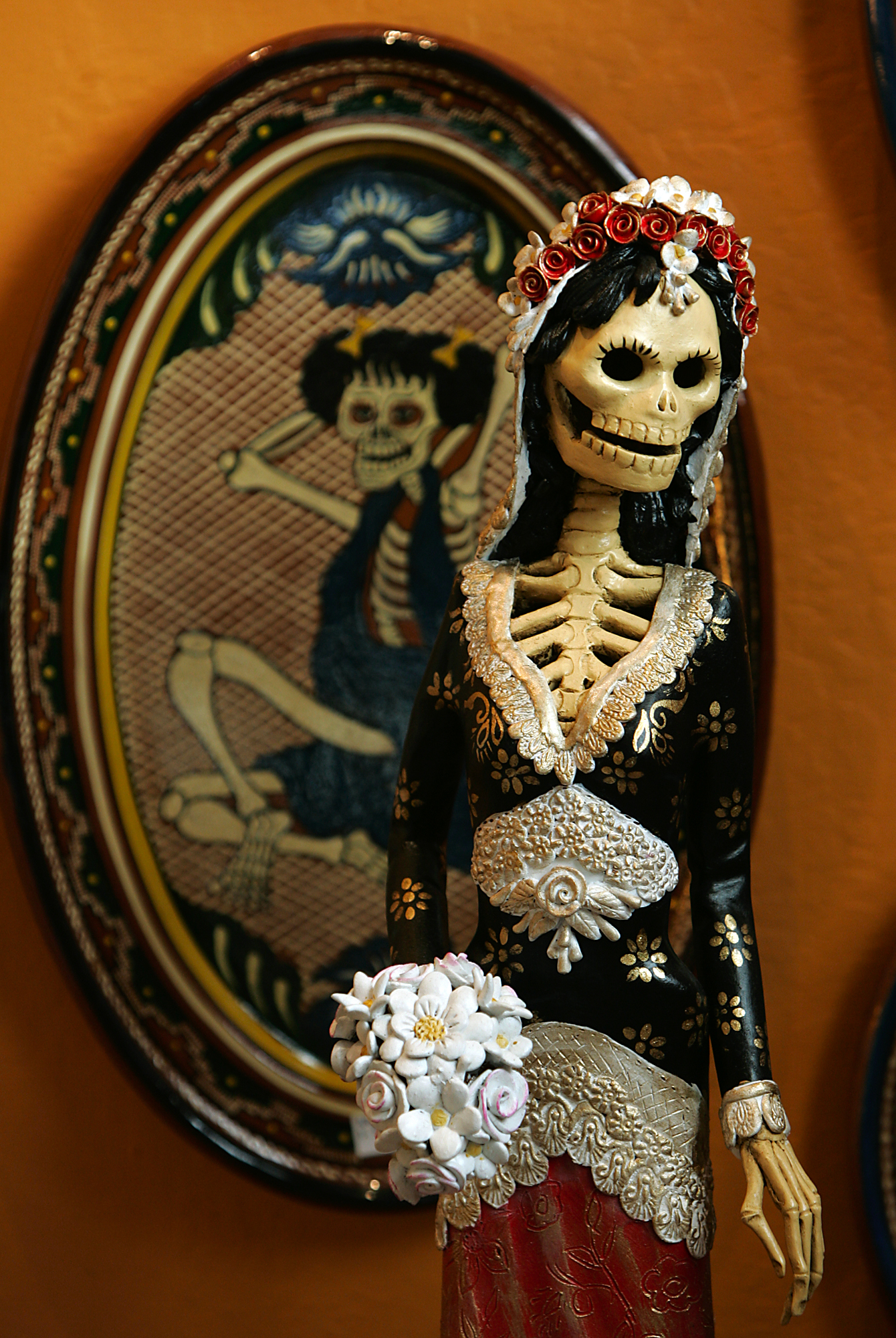 11/1/2009:D9: A skeletal figurine with guitar at the Petaluma Arts Center. PC: Catrina figures, a parody of the Mexican upper class female with bouquet often are a prominent part of modern Day of the Dead observances.