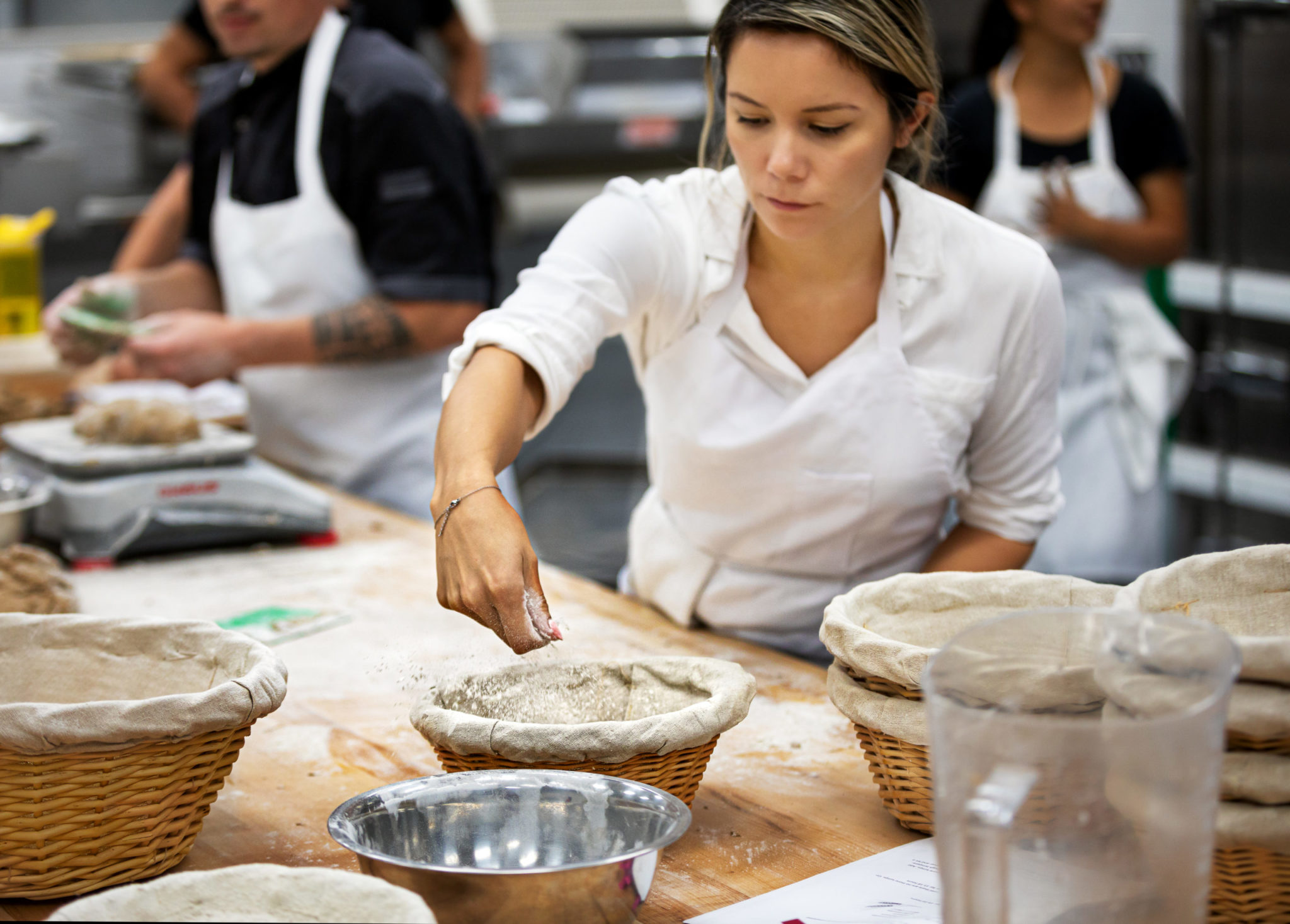 Student Gabrielle Scrimshaw flours proofing baskets before handling a batch of dough. (Chris Hardy)