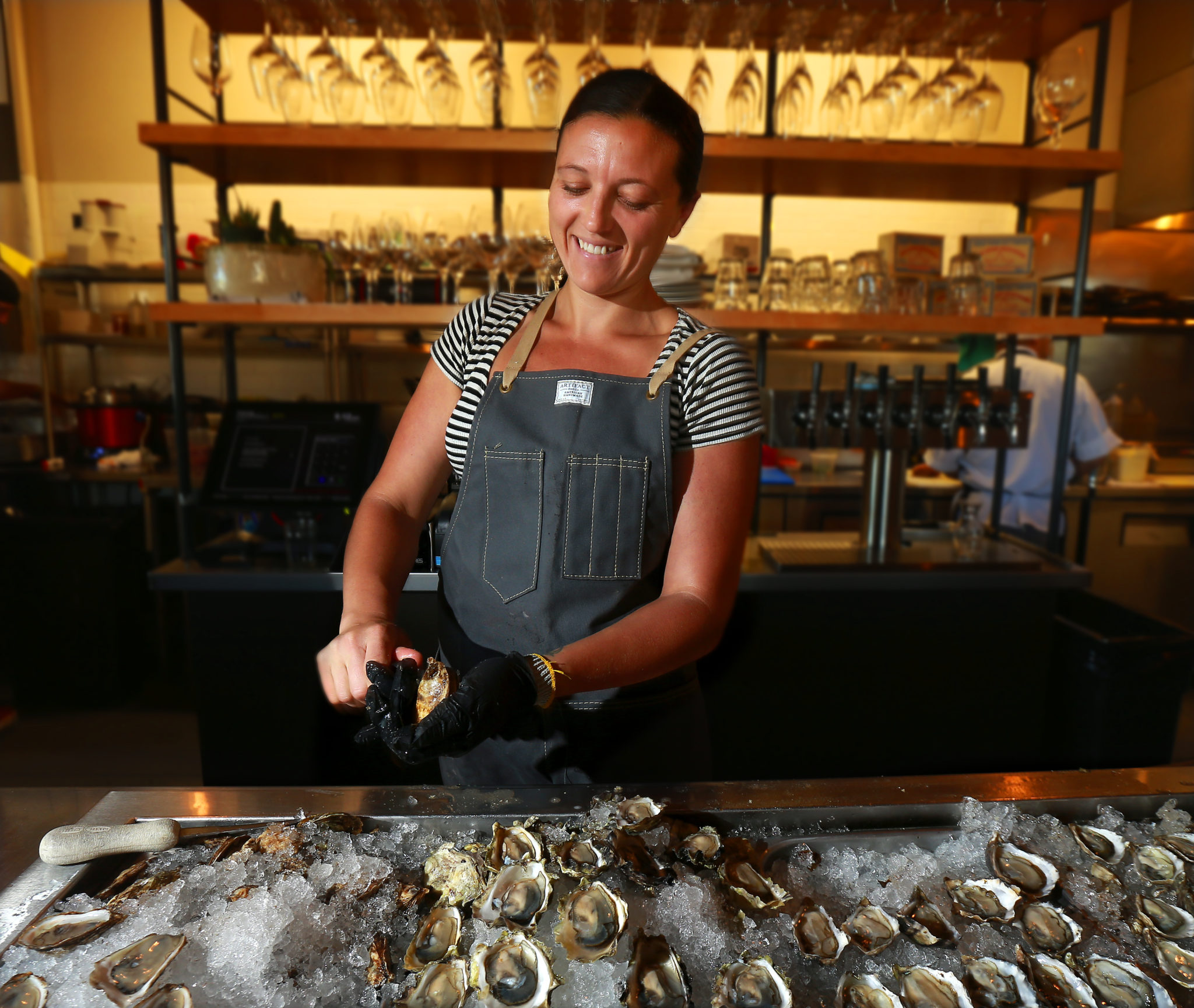 Zoe Kimberly shucks oysters at The Shuckery in Petaluma. (John Burgess/The Press Democrat)