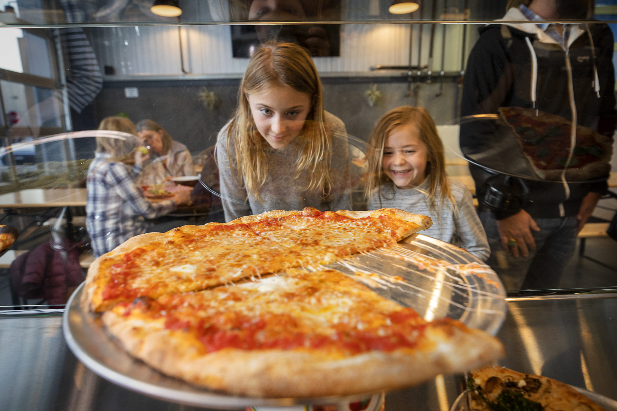 Sailor, left, and Lila Burt of Sebastopol check out the pizza varieties while their parent order at the new Acre Pizza in Sebastopol's Barlow district. (John Burgess/The Press Democrat)