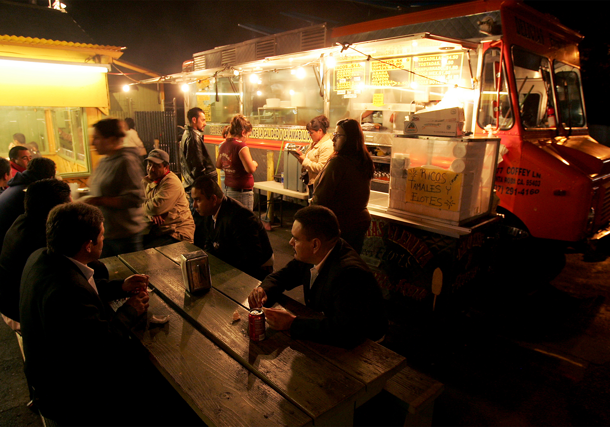 9/11/2006: B1: LEISURELY TALKS: In the parking lot of La Fondita restaurant in Roseland, customers order and pick up their food from Delicias Elenita, one of two taco trucks located at each corner of West Avenue and Sebastopol Road, on Friday. PC: News lede/ --3 of 3--in the parking lot of La Fondita restaurant in Roseland, customers order and pick up their food from Delicias Elenita one of two mobile taco trucks located at each corner of West Avenue and Sebastopol Road, Friday September 8, 2006. Fernando Reyes (not pictured ) owns La Fondita and the two trucks. (Kent Porter / The Press Democrat) 2006