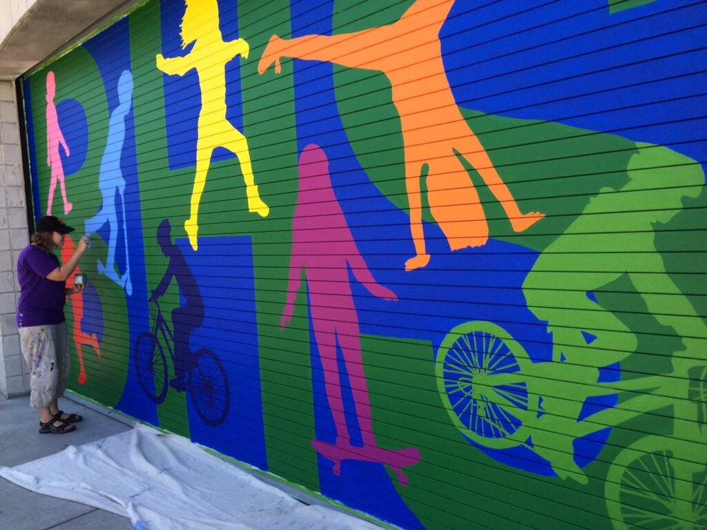 Sebastopol artist Dana Lynn Vallarino paints a mural at Brook Haven School in Sebastopol. (Christopher Chung/ The Press Democrat)