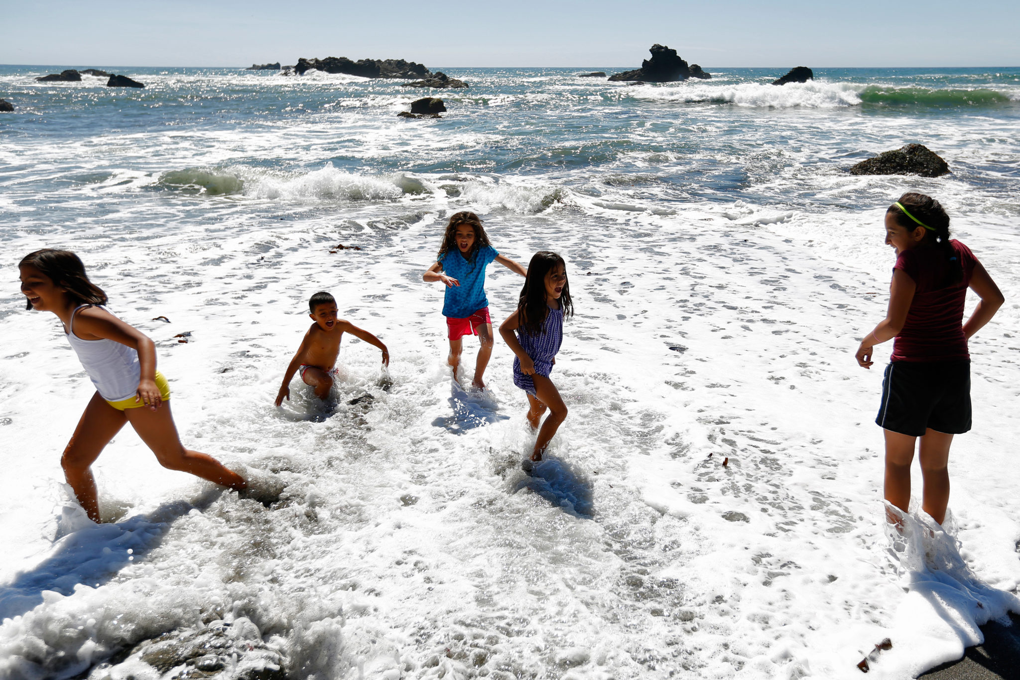 Children with the Latino Outdoors program play in the surf at Shell Beach south of Jenner, California on Sunday, September 6, 2015. (Alvin Jornada / The Press Democrat)