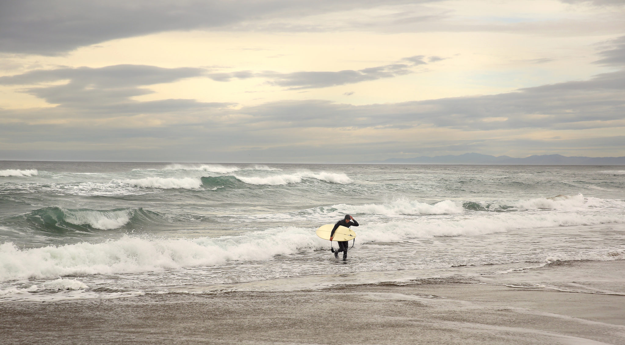 Daniel Arreguin heads back from a surf session along the Fort Bragg coastline on Wednesday, February 26, 2014. (Conner Jay/The Press Democrat)